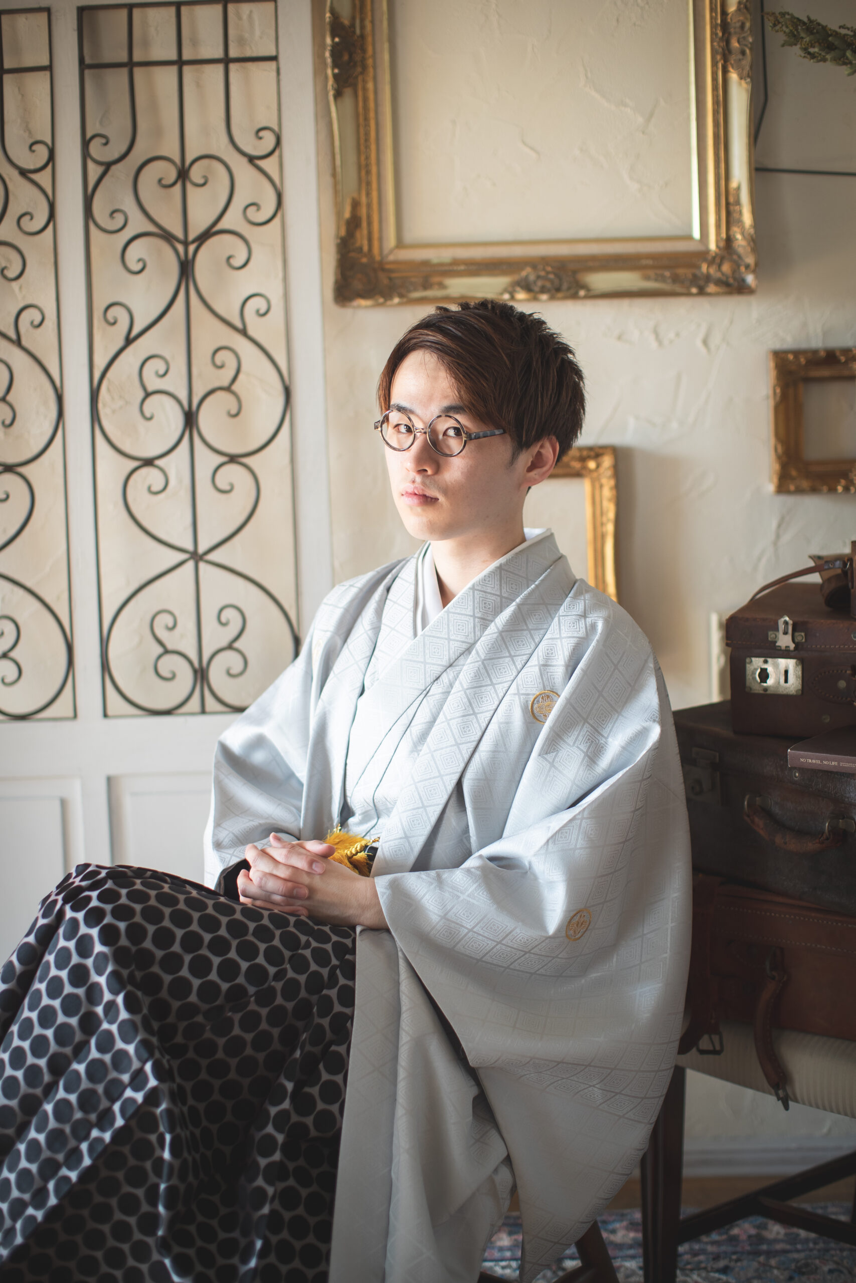 椅子に座ってメガネをかけた袴姿の男性
